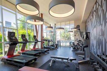a gym with cardio equipment and windows in the lobby of a building at Astro Apartments, Seattle